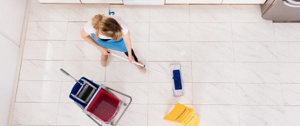 Housemaid Mopping Floor In Kitchen